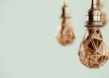 Unusual 3d illustration of hanging stylized low poly light bulbs with golden wire. Conceptual background
